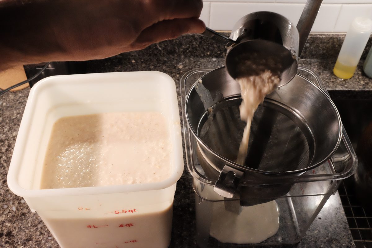 straining brew through fine mesh strainer