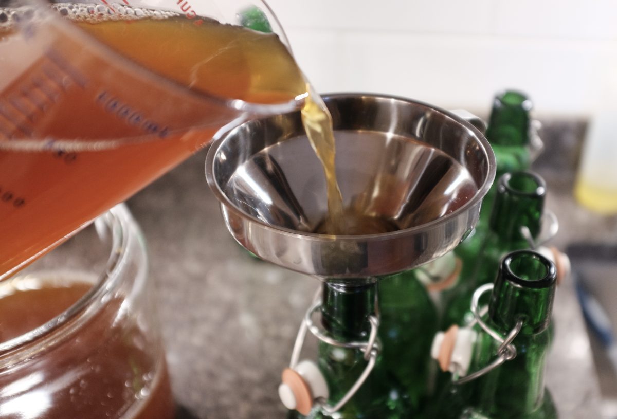 adding brew to bottles using funnel