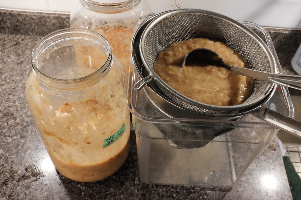 mash ladled into strainers 