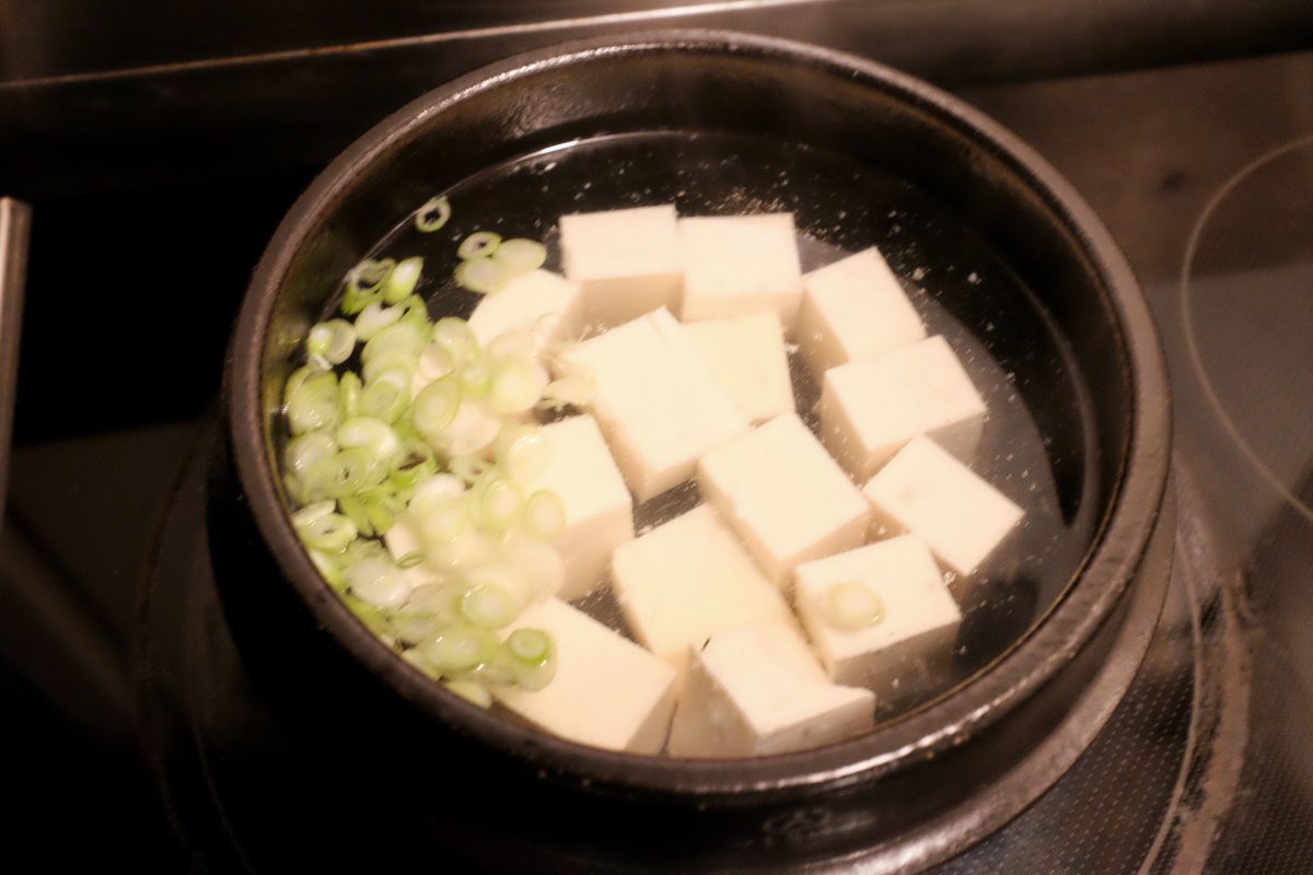 adding tofu and green onion white parts
