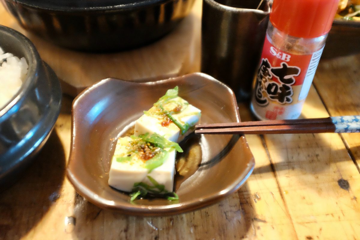 perfect tofu bite with sauce, green onion and togarashi spice