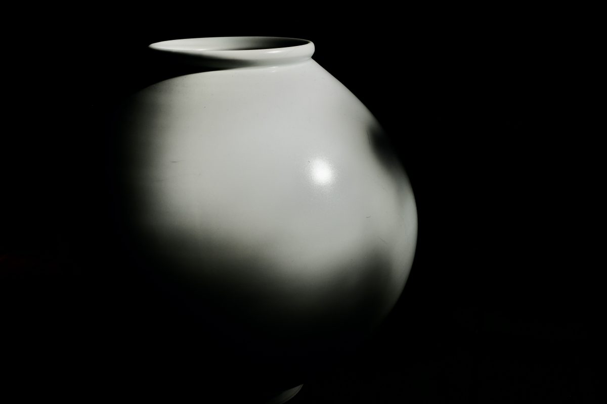 a moon jar lit from one side by sun