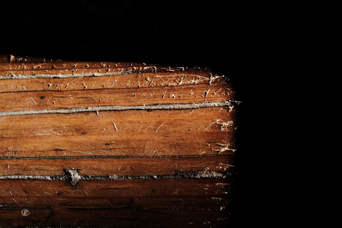 a table corner with pinholes made by cat claws